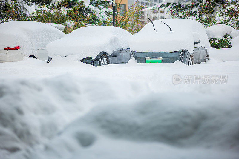 被大雪困住的汽车一动不动地停在房子院子里的雪地里