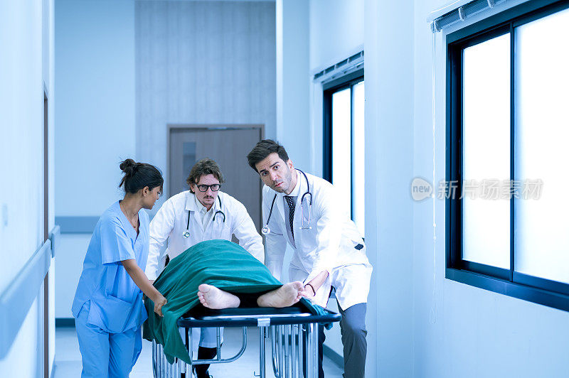 医生、护士和护理人员推着担架床，抬着重伤病人走向手术室。专业人员拯救生命。医疗保健概念。