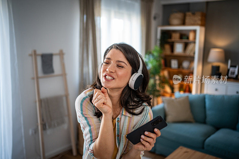 一个年轻的女人喜欢生活的节奏和播放列表上的好音乐