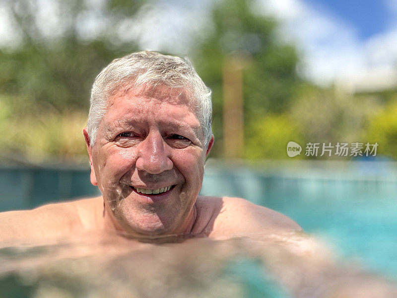 年长的白人男子在室外泳池自拍