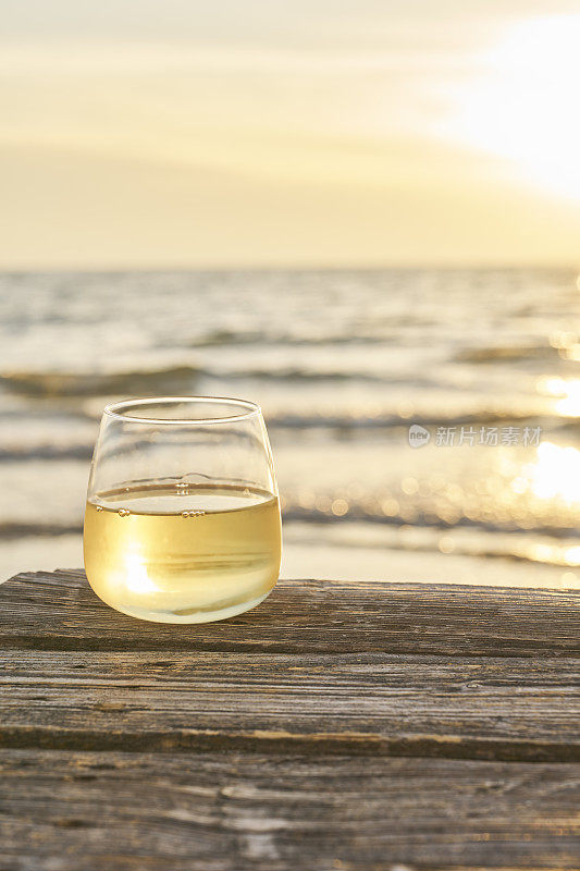 海滩上的桌子上有一杯酒