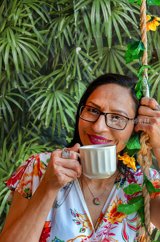 白天，一位微笑的女士在一家热带主题咖啡馆享受着一杯咖啡