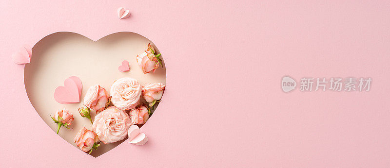 精致的母亲节展示:玫瑰的俯视图，在柔软的粉红色表面心形框架中的纸心，文字空间为问候或广告