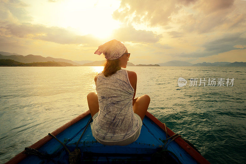 日落时分，一个女人在船上漂着