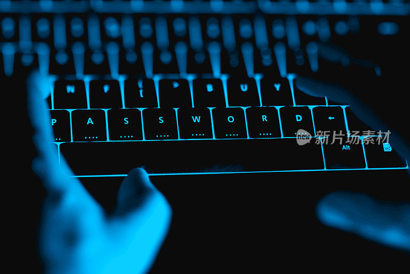 黑客晚上在发光的键盘上打字。