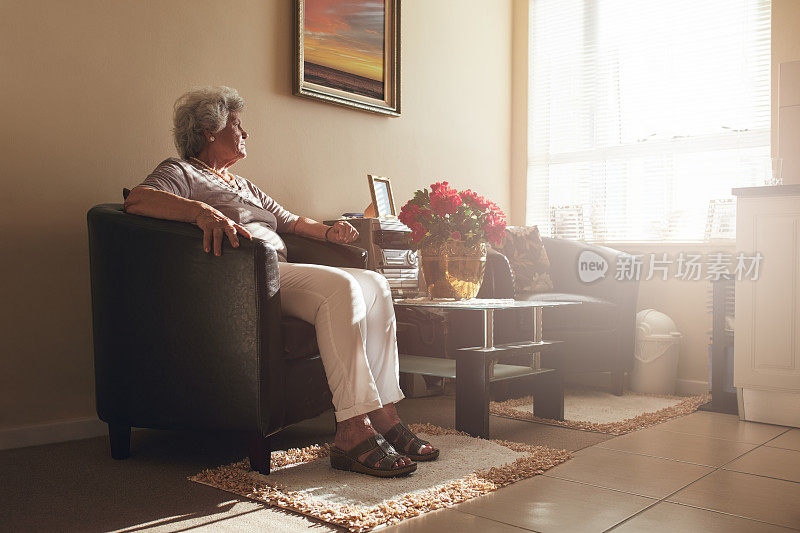 一个女人独自坐在家里的椅子上