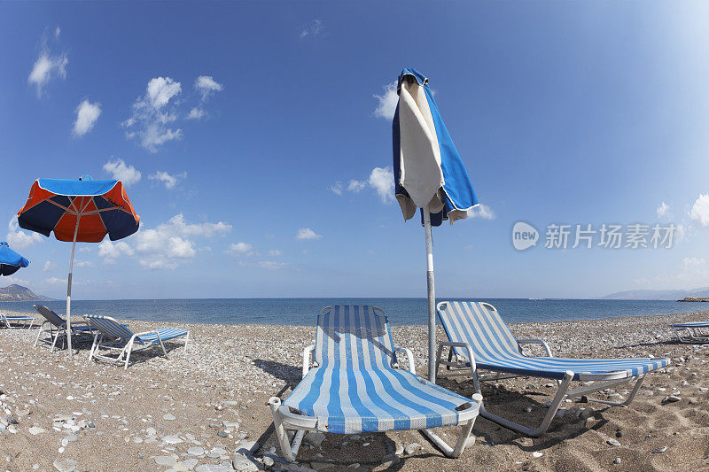 两个鱼眼彩色日光浴床和雨伞拉斯海滩塞浦路斯