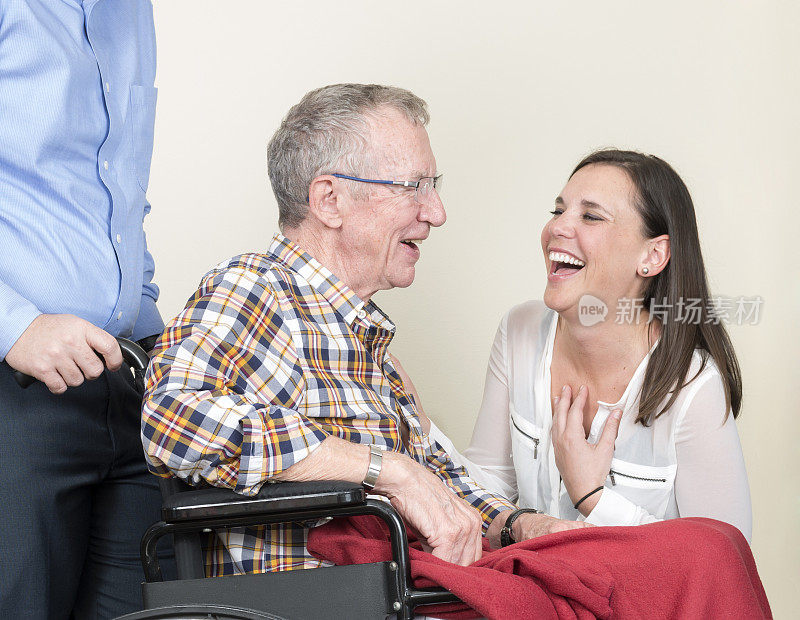 坐在轮椅上的老人被家人团团围住