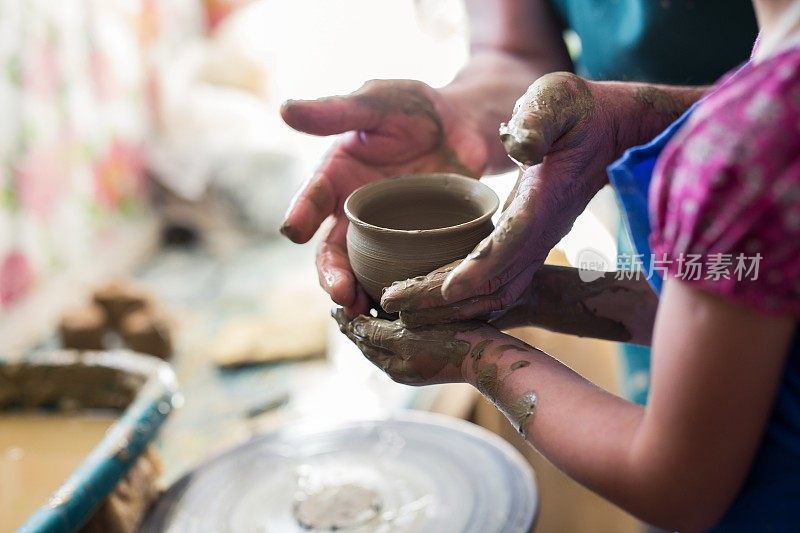 女孩在雕刻轮上做一个陶土碗