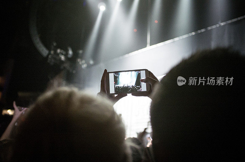人群在音乐会上用手机拍照