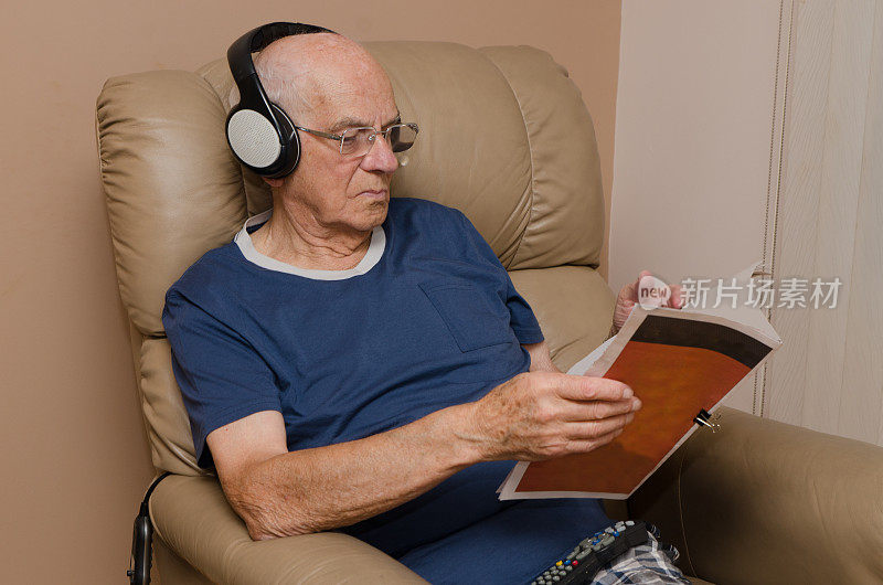 戴着耳机看杂志的老人