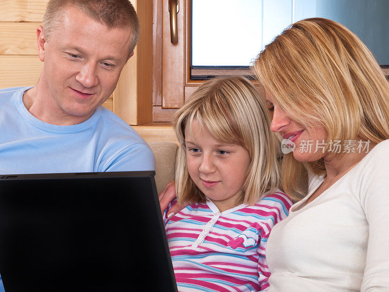 父母和女儿使用笔记本电脑