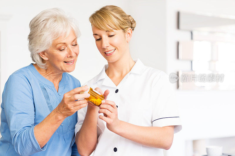 护士和年长妇女检查一个药瓶