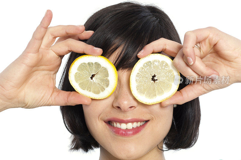 一个年轻女人拿着两块柠檬片