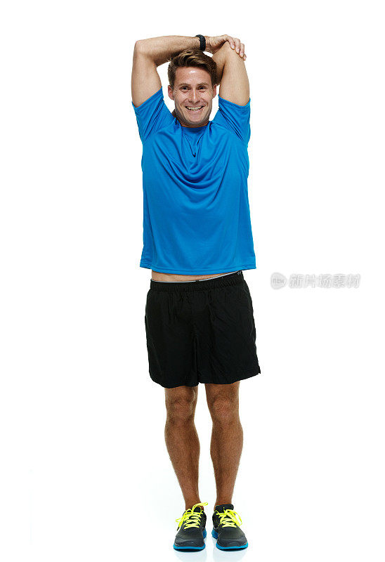 微笑的男性跑步者伸展身体