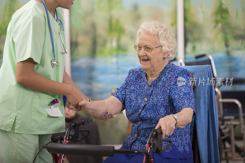 照顾拉丁后裔护士帮助老年病人使用她的助行器。