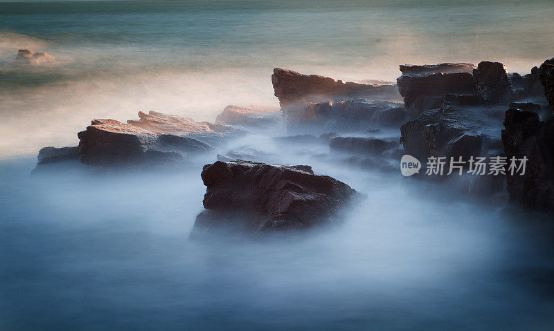 日出时，阿卡迪亚国家公园的海浪拍打着岩石。
