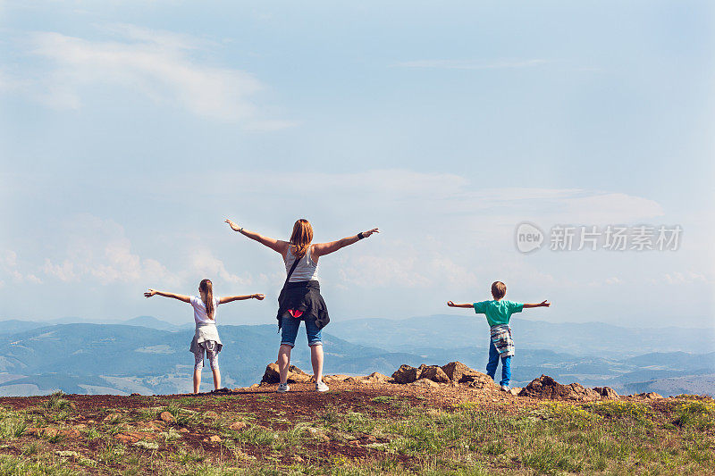 母亲和她的孩子们一边运动一边欣赏山景