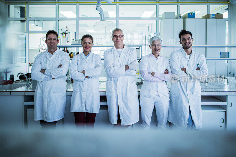 实验室里一群抱着双臂的快乐科学家。