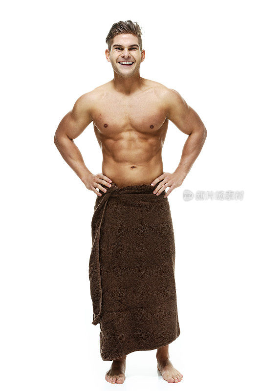 肌肉发达的男人在毛巾和站与手在臀部