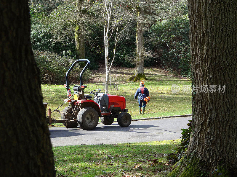 人们用拖拉机、汽油草坪修剪机和安全帽做园艺