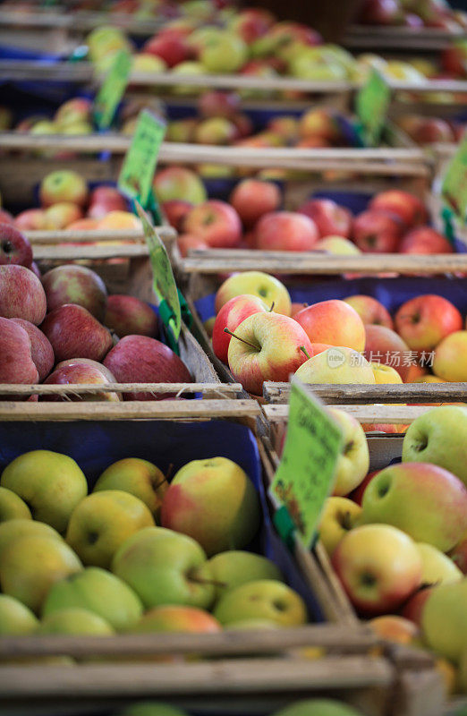 农贸市场上各种各样的盒子里的苹果