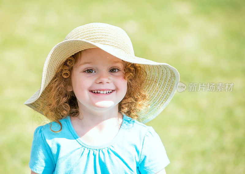 快乐的年轻女孩在春天戴着帽子