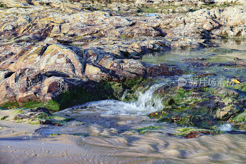 湍急的水流穿过带有藻类的岩石
