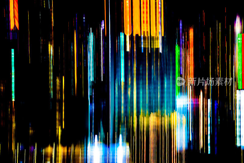 在繁忙的城市中移动多彩的线条或光画LED建筑抽象灯光轨迹，彩虹和混乱的黑色背景。垂直设计