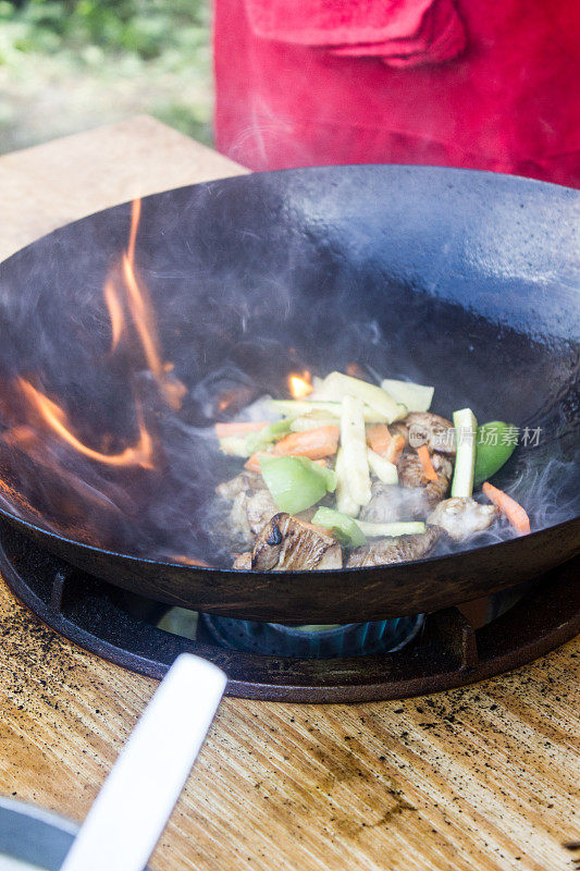 传统的中国食物-炒锅在明火上烹饪。