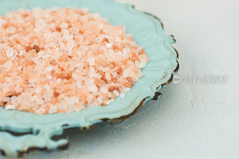 粉色喜马拉雅盐在复古绿松石盘子白色石头桌面健康水疗健康饮食营养阿育吠陀干净极简形象复制空间