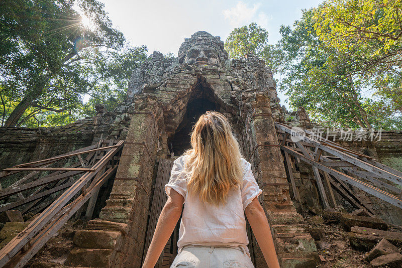 旅游女游客站在寺庙复杂的大门前仰望上面的雕塑，人们发现探索的概念