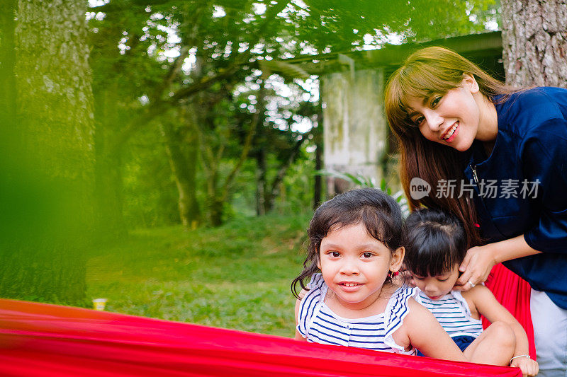 夏天的时候，亚洲小孩在吊床上玩耍