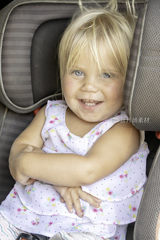小女孩坐在她的汽车座椅上