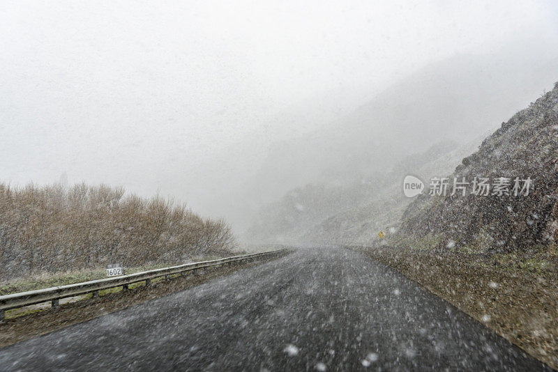 道路有积雪，左侧有防护条