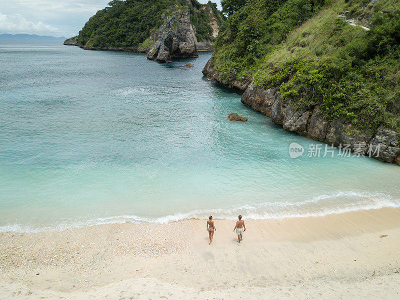 鸟瞰热带海滩上的年轻情侣享受度假和大自然，人们旅游探险的理念