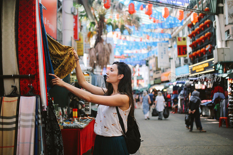 年轻的旅行者女人在吉隆坡唐人街区购物