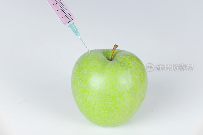 青苹果注射器。转基因食品概念。
