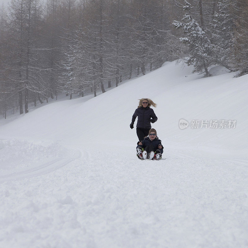 一个女人在雪地上追雪橇手