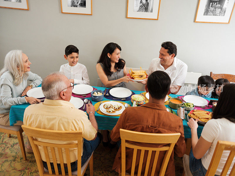 墨西哥家庭在餐桌上互相传递食物