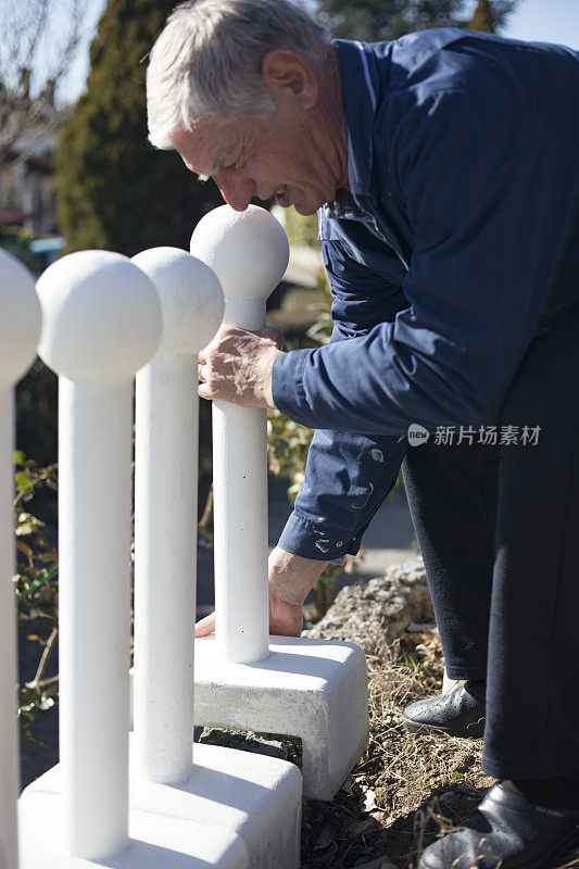 在前院翻新和建造新围栏的高级男子