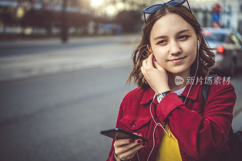 夏天在街上拿着智能手机的少女