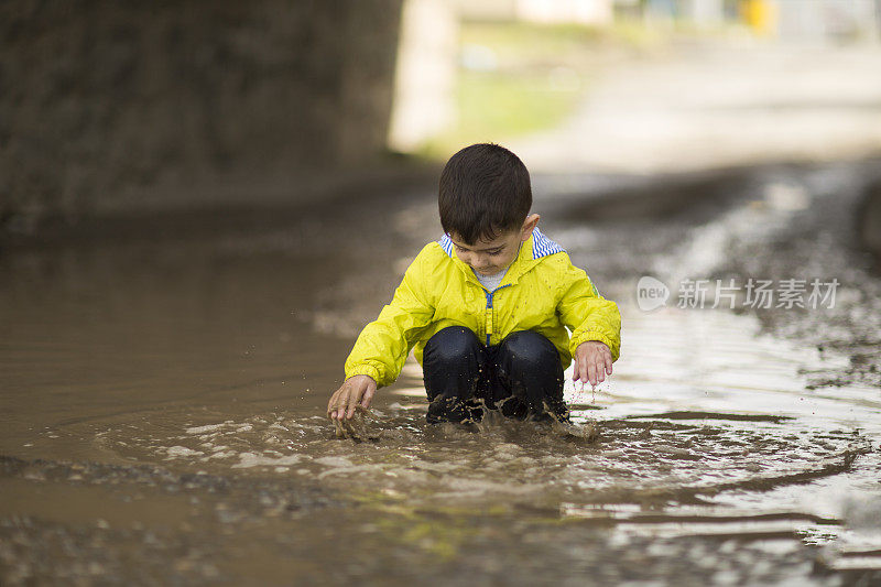 孩子们在雨坑里玩耍