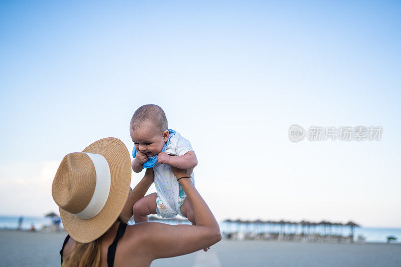 一个在海滩上抱着婴儿的陌生女人