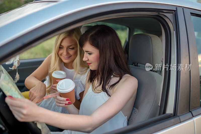 年轻女子正在开车，一边看地图。