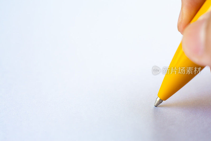 女人的右手拿着一支黄色的笔，在白纸背景上写信，笔记本，特写和微距镜头，选择性聚焦，沟通，文具概念