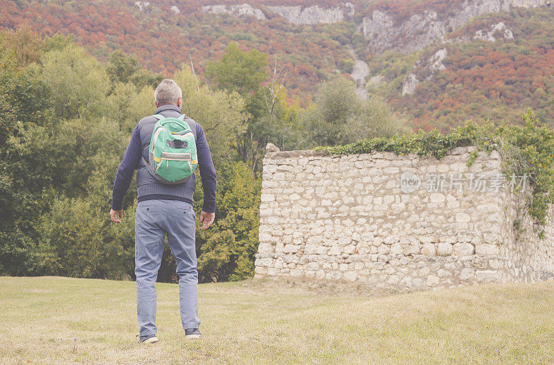 一名成年男子于秋日在美丽的山林中徒步旅行