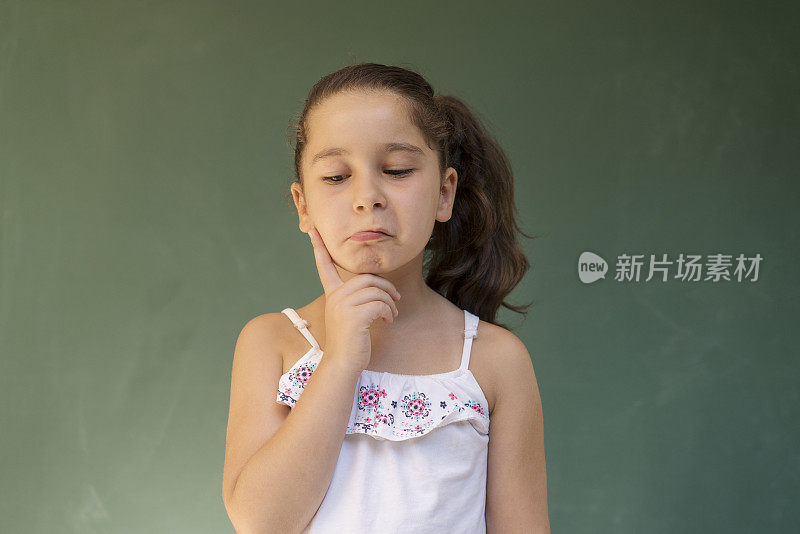 沉思的女孩抬头，绿色的背景