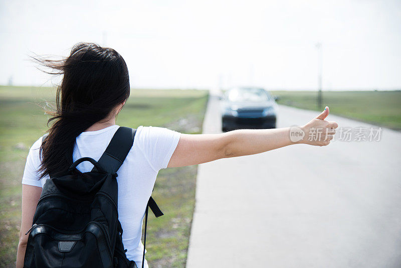 女人竖起大拇指让她搭车