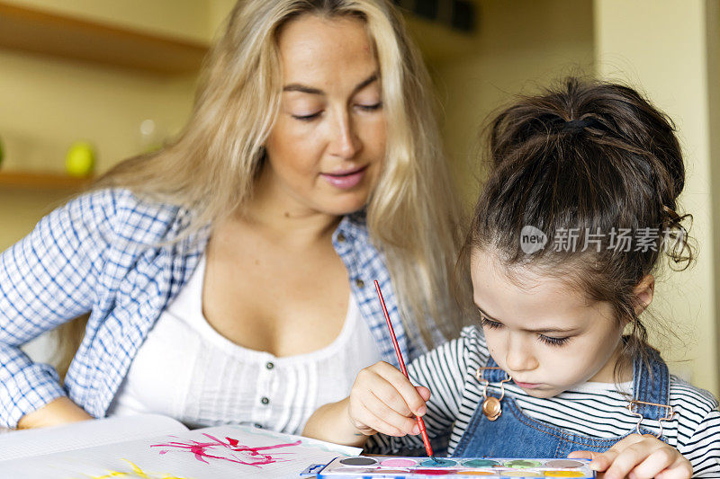 小女孩正在用水彩画